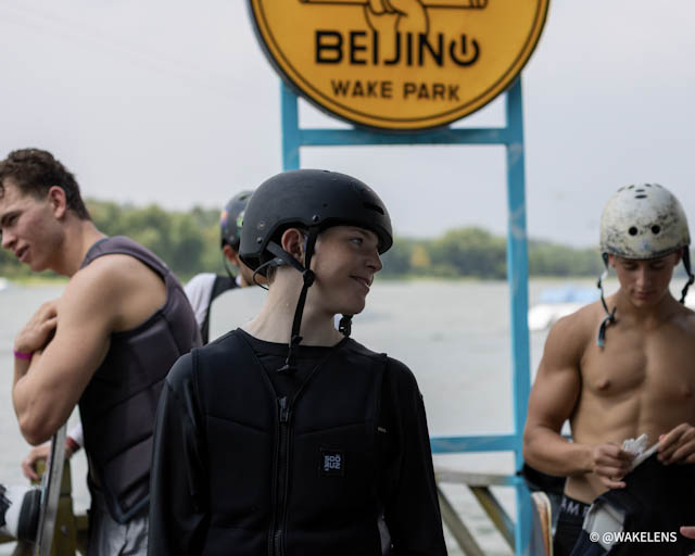 Athleten des deutschen Teams mit Helmen und Westen vor dem Eingangsschild der Anlage im Shunyi Olympic Cable Park